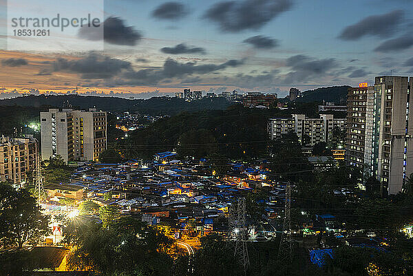 Blick auf einen von Hochhäusern umgebenen Slum bei Sonnenuntergang; Mumbai  Maharashtra  Indien