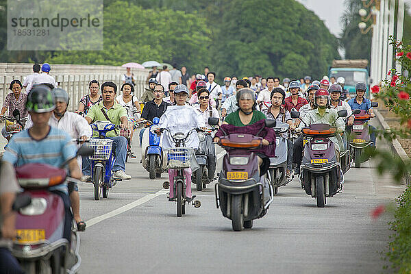 Menschen  die frühmorgens auf Fahrrädern und Motorrollern auf einer separaten Spur in der Stadt Nanning  Guangxi  Südwestchina  pendeln; Nanning  Guangxi  China