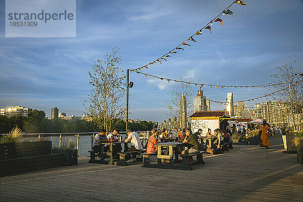 Kunden essen im Freien an Tischen auf der Battersea Power Station Deck Bar  Südlondon  London  UK; London  England