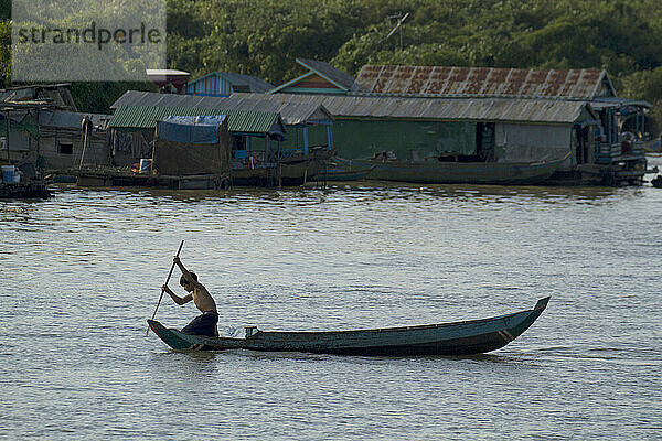 Kind steuert ein Boot auf dem Tonle Sap oder dem schwimmenden Dorf; Tonle Sap  Kambodscha