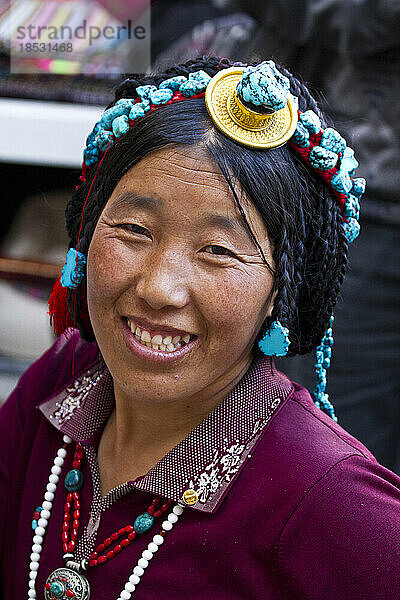 Lächelnde Frau mit Kopfschmuck auf dem Borkhar-Markt; Lhasa  Tibet