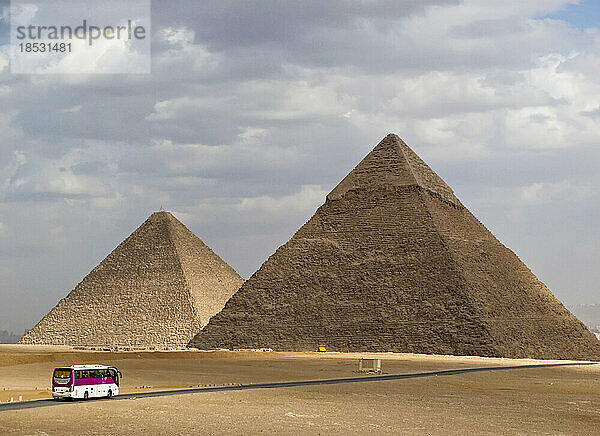Touristenbus  der sich zwei der Großen Pyramiden von Gizeh nähert; Gizeh  Ägypten