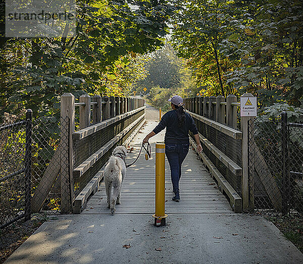 Frau geht mit ihrem Hund in einem Park spazieren; Vancouver Island  British Columbia  Kanada