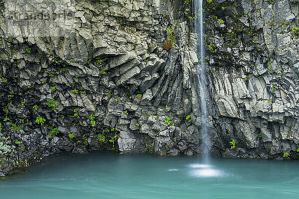 Kleiner Wasserfall stürzt an Basaltformationen vorbei in der Nähe des Gullfoss-Wasserfalls in Island; Island