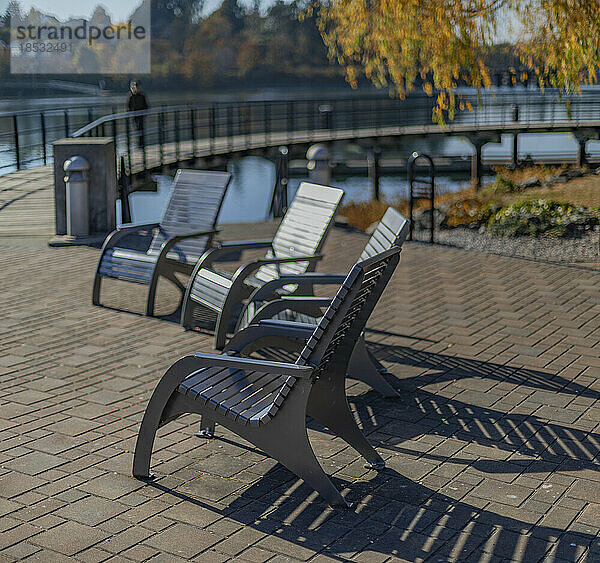 Stühle im Sonnenlicht entlang einer Uferpromenade; Victoria  British Columbia  Kanada