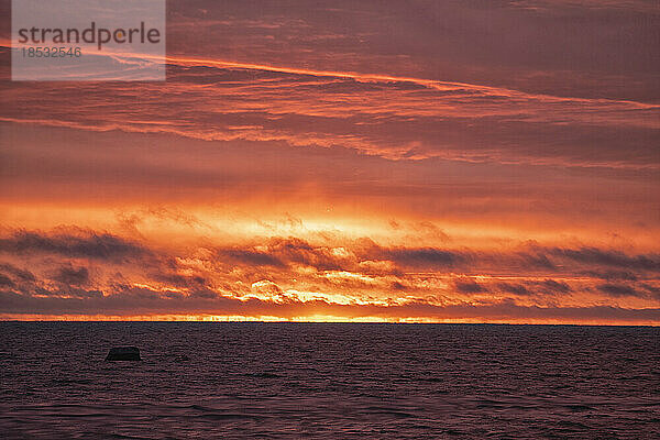 Glühender Sonnenaufgang am Himmel über der Hudson Bay; Churchill  Manitoba  Kanada