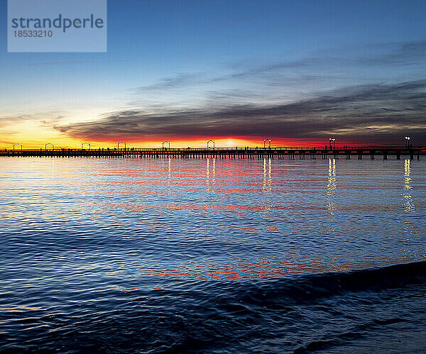 Kräftige Farben des Sonnenuntergangs am Himmel über der Silhouette des White Rock Piers; White Rock  British Columbia  Kanada