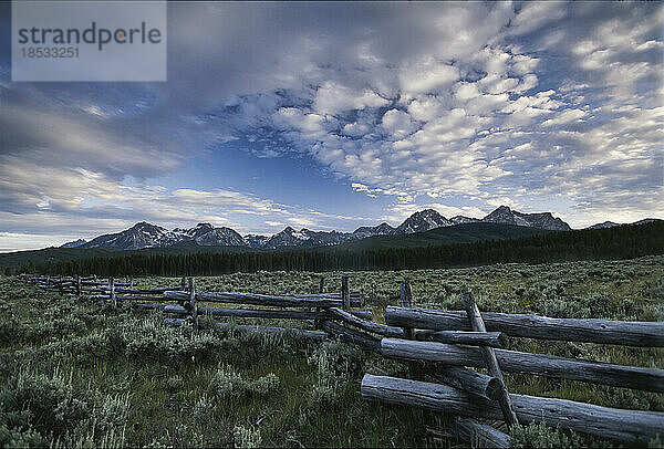 Die Sawtooth Range  ein Teil der Rocky Mountains  bildet die Kulisse für einen Zaun aus gespaltenen Stäben; Idaho  Vereinigte Staaten von Amerika