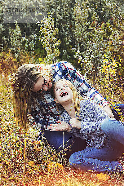Mutter und Tochter verbringen Zeit miteinander im Freien  spielen und lachen zusammen in einem Park im Herbst; Edmonton  Alberta  Kanada