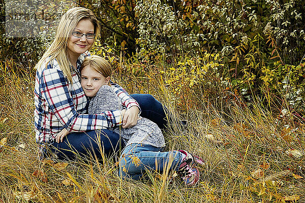 Außenporträt einer Mutter mit ihrer Tochter in einer Umarmung; Edmonton  Alberta  Kanada