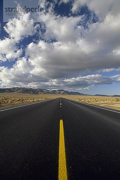 Langer  gerader Highway ohne Autos  der sich bis ins Unendliche erstreckt; Nevada  Vereinigte Staaten von Amerika