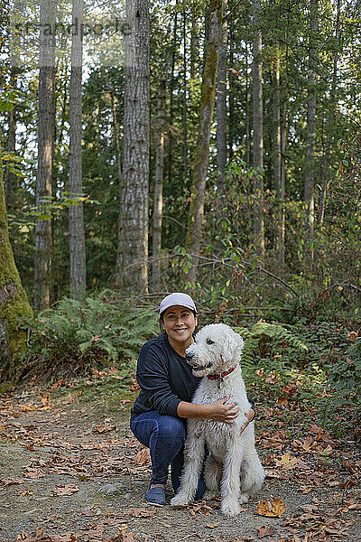 Porträt einer Frau mit ihrem Hund in einem Waldgebiet; Vancouver Island  British Columbia  Kanada