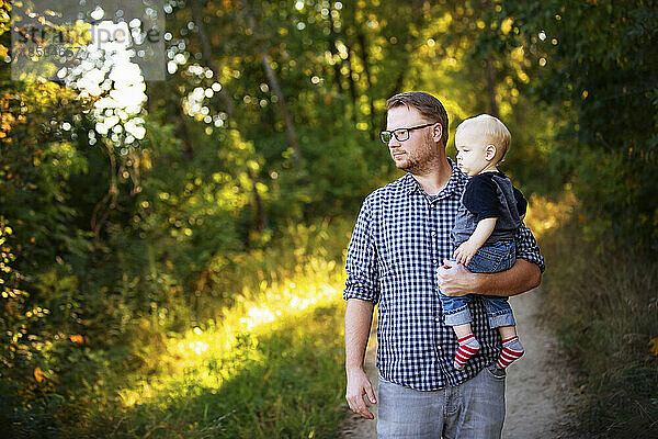 Vater geht mit seinem kleinen Jungen im Freien in einem Park spazieren; Edmonton  Alberta  Kanada