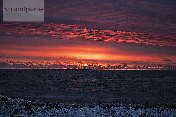 Kräftige Farben leuchten in einem dramatischen Sonnenaufgangshimmel über der Hudson Bay; Churchill  Manitoba  Kanada