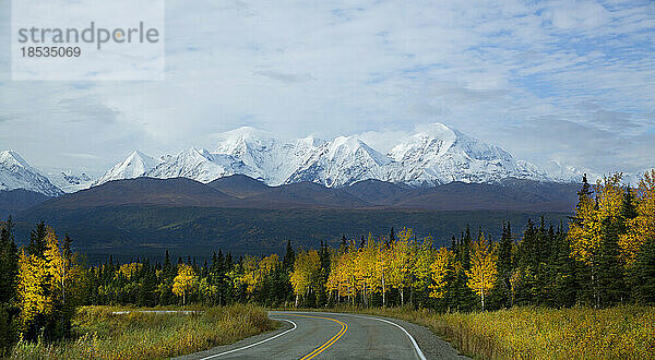 Ein kurvenreicher Highway offenbart einen atemberaubenden Herbstblick auf die Rainbow Ridge Mountains; Alaska  Vereinigte Staaten von Amerika