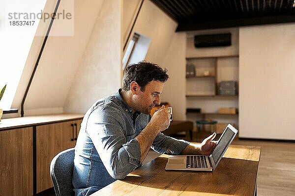 Lächelnder  bärtiger  kaukasischer Geschäftsmann arbeitet am Laptop im Büro zu Hause. Brunette Studentin verwenden Computer Fernunterricht um Videoanruf Lernen  beobachten Online Webinar oder Seminar
