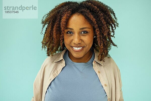 Fröhlich gut aussehende sorglos junge afrikanische amerikanische Frau zeigt beruhigen  versichern alle gut und lächelnd  stehend blaün Hintergrund zufrieden. Glückliche schwarze Frau