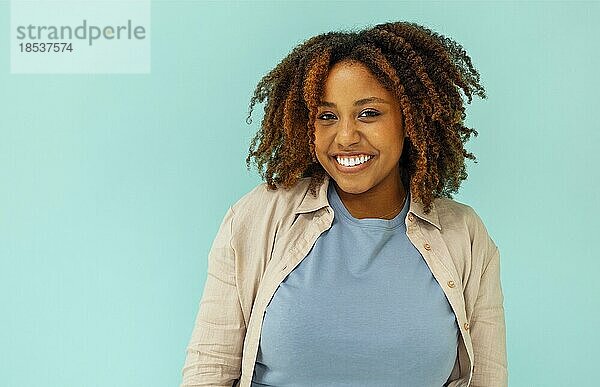 Fröhlich gut aussehende sorglos junge afrikanische amerikanische Frau zeigt beruhigen  versichern alle gut und lächelnd  stehend blaün Hintergrund zufrieden. Glückliche schwarze Frau