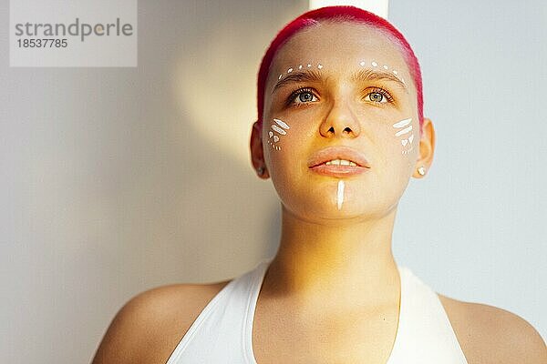 Schöne entspannte Frau mit ungewöhnlichem Make up und roten Haaren beim Ausruhen an einem sonnigen Wochenendtag zu Hause. Körper positives Konzept