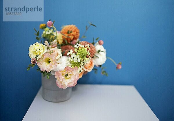 Glasvase mit einem Strauß schöner Blumen auf dem Tisch in einem gemütlichen Zimmer. Platz für Text