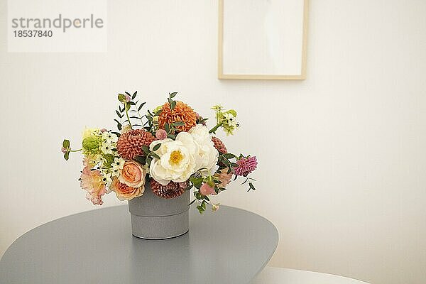 Glasvase mit einem Strauß schöner Blumen auf dem Tisch in einem gemütlichen Zimmer. Platz für Text