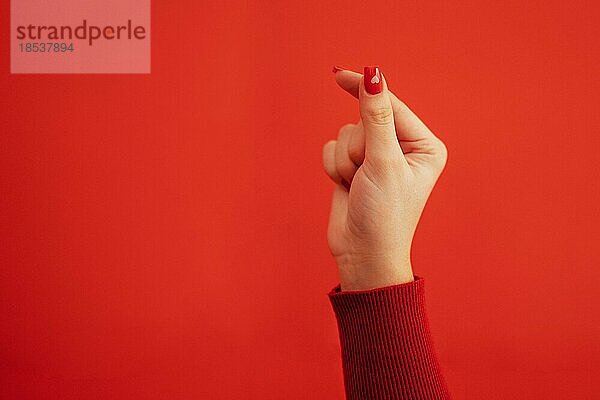 Das koreanische Symbol für Liebe ist offensichtlich. Die Hand einer Frau bedeckt ein Herz. Platz für Text. Alles Gute zum Valentinstag