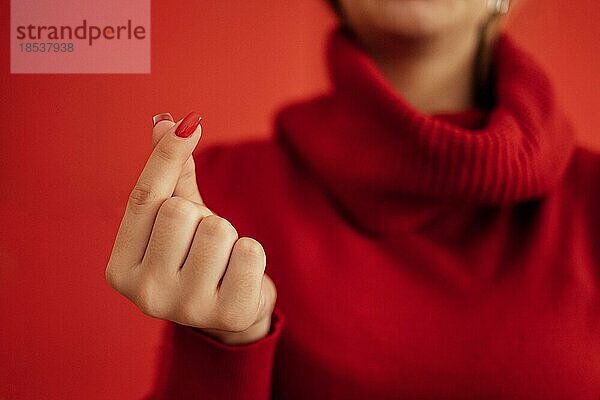 Das koreanische Symbol für Liebe ist offensichtlich. Die Hand einer Frau bedeckt ein Herz. Platz für Text. Alles Gute zum Valentinstag