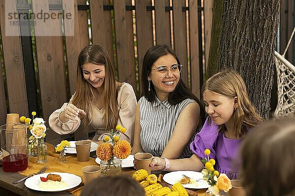 Glückliche Kinder und Jugendliche auf Geburtstagsparty im Sommergarten im Freien. Urlaub  Kindheit  Freundschaft und Feier Konzept