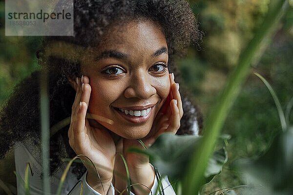 Close up Porträt der hübschen jungen afroamerikanischen Frau auf Gras liegend. Schöne afro Mädchen in einem weißen Hemd entspannt im Park. Natürlichkeit und Hautpflege Konzept. Freie Kopie spase