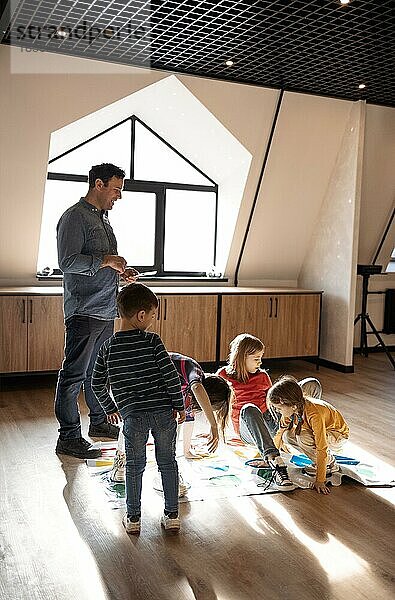 Glückliche große Familie  die Spaß zusammen  Kinder mit Vater spielen Twister Spiel zu Hause. Familie Aktivität