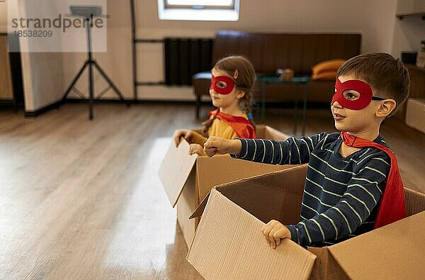 Superhelden Kinder. Superheldenkinder  Bruder und Schwester  spielen zu Hause. Bewegendes  erfolgreiches und fröhliches Spielkonzept