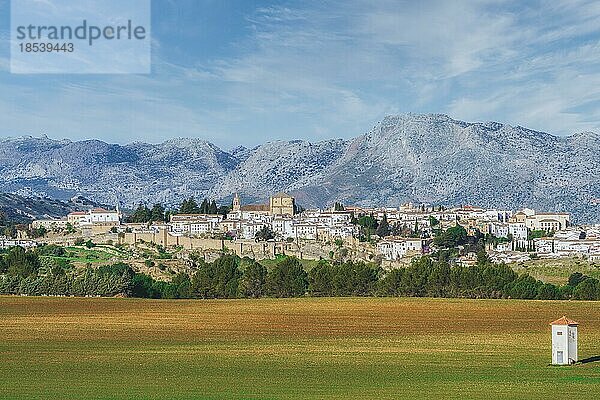 Panoramablick auf die Stadt Ronda  Andalusien  Spanien mit riesigen Bergen im Hintergrund und Ackerland im Vordergrund