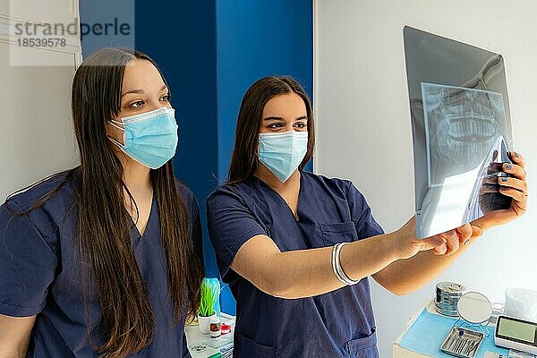Zwei Zahnärzte mit Erfahrung in der Röntgenuntersuchung eines menschlichen Kiefers in der Zahnarztpraxis