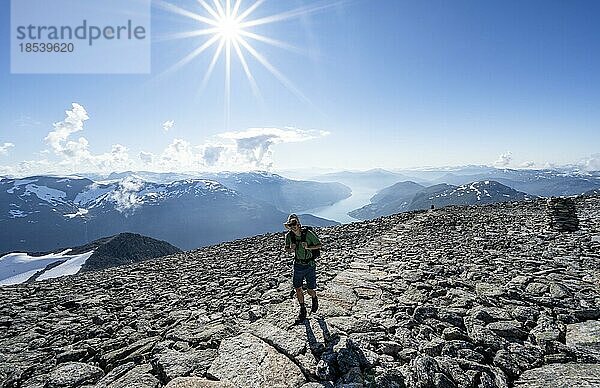 Wanderer beim Aufstieg zum Gipfel des Skåla  Ausblick auf Berge und Fjord Faleidfjorden  Sonnenstern  Loen  Norwegen  Europa