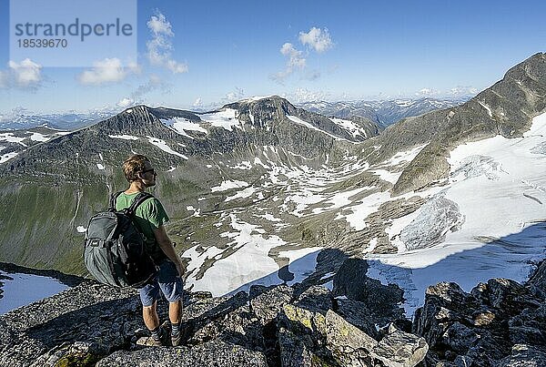 Wanderer beim Aufstieg zum Gipfel des Skåla  Ausblick auf Berge Geitafjellhyrna und Storskredfjellet mit Gletscher  Loen  Norwegen  Europa