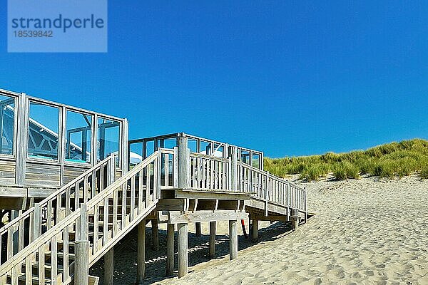 Treppe  die zu einem kleinen hölzernen Strandpavillon Restaurant namens Paal 19 führt  an einem Sommertag auf der Insel Texel in den Niederlanden