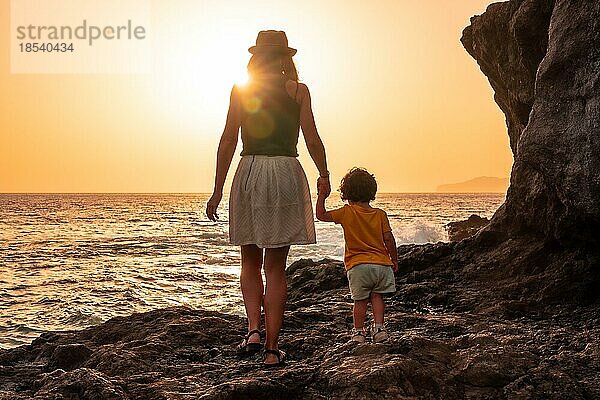 Mutter und Sohn bei Sonnenuntergang am Strand von Tacoron auf El Hierro  Kanarische Inseln  Urlaubskonzept  oranger Sonnenuntergang