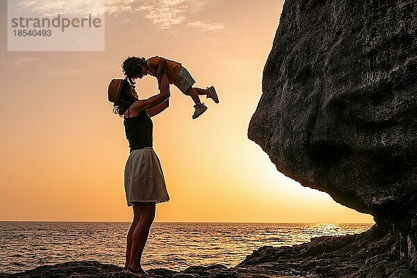 Silhouette von Mutter und Sohn  die sich bei Sonnenuntergang am Strand von Tacoron auf El Hierro  Kanarische Inseln  Urlaubskonzept  orangefarbener Sonnenuntergang