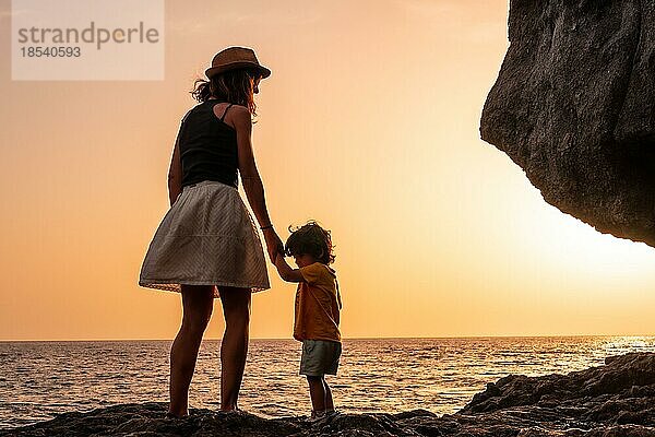 Silhouette von Mutter und Sohn bei Sonnenuntergang am Strand von Tacoron auf El Hierro  Kanarische Inseln  Urlaub Konzept  orange Sonnenuntergang