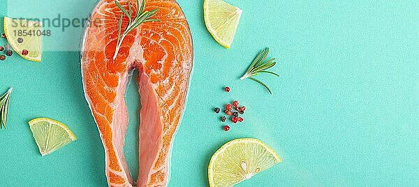 Ungekochte rohen frischen Fisch Lachssteak Draufsicht auf blauem Hintergrund mit Rosmarin  Zitrone Keile und Gewürze  Delikatesse gesunden Fisch Kochen und Ernährung Konzept flach legen Kopie Raum