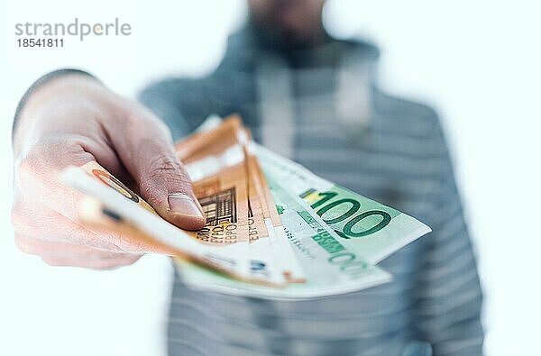 Mittelteil eines Mannes  der Geldscheine in der Hand hält und sie jemandem übergibt  der mit Bargeld bezahlen will