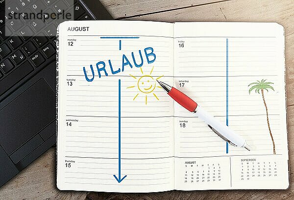 Draufsicht auf einen Kalender auf einem Tisch mit dem Wort URLAUB und einem Sonnensymbol auf einem Holztisch