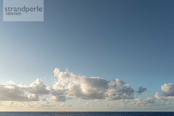 Schöne Wolken und klaren blaün Himmel über dem Meer bei Sonnenuntergang Hintergrund