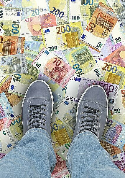 Das Geld liegt auf der Straße Eine Person steht auf Euro-Banknoten im Hochformat