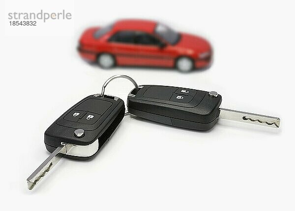 Zündschlüssel mit Auto im Hintergrund. Ignition keys with car in the background