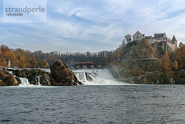 Horizontale Ansicht eines Zuges mit rotem Pfeil  der auf der Brücke am Rheinfall hält  um die wunderschöne Wasserfalllandschaft und das Schloss Laufen in der Schweiz zu betrachten
