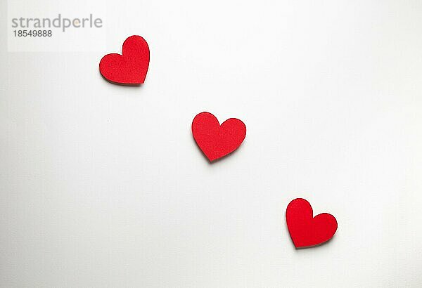 Drei rote Herzen in einer Reihe aus Papier auf weißem Hintergrund geschnitten  Handwerk OrigamiStil von oben. Romantische Valentinstag Liebe Konzept. Drei Herzen in Linie Draufsicht  Papier Kunst Design