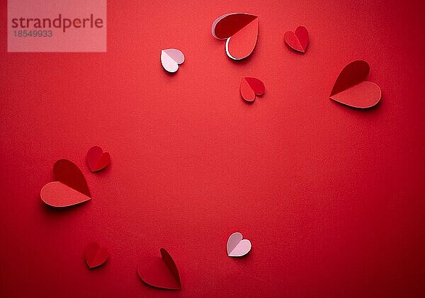 Rote und rosa Herzen aus Papier auf roten monochromen Hintergrund  Papier Handwerk OrigamiStil von oben geschnitten. Romantische Valentinstag Kulisse  Liebe Konzept. Papier trendy Kunstdesign Platz für Text