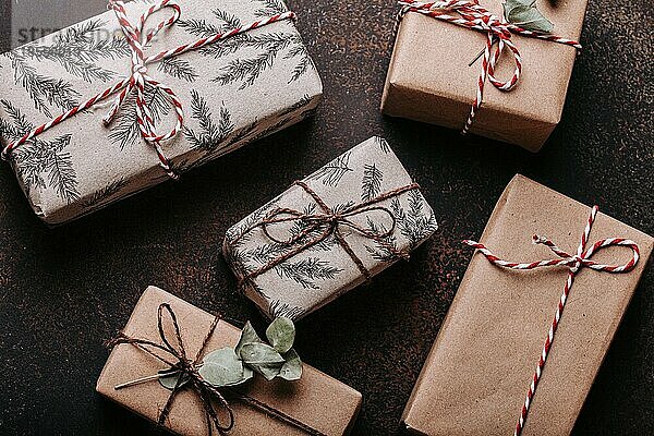 Minimalistische Weihnachtsgeschenke flach legen Zusammensetzung auf dunklen konkreten Hintergrund. Weihnachten und Neujahr elegante Geschenkboxen Draufsicht