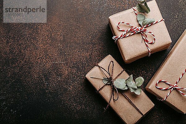 Minimalistische Weihnachtsgeschenke flach legen Zusammensetzung auf dunklen konkreten Hintergrund. Weihnachten und Neujahr elegante Geschenkboxen Draufsicht mit Freiraum für Textvorlage